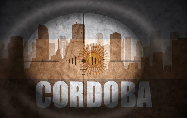 Sniper scope aimed at the abstract silhouette of the city with text Cordoba at the vintage argentinian flag. concept — Zdjęcie stockowe