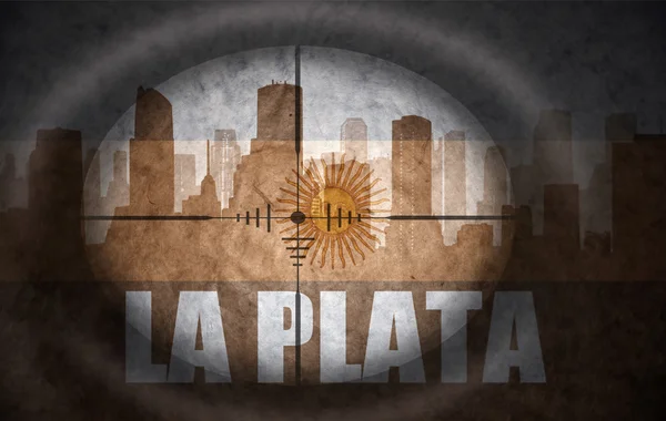 Sniper scope aimed at the abstract silhouette of the city with text La Plata at the vintage argentinian flag. concept — Zdjęcie stockowe