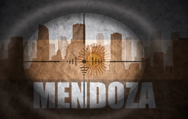 Sniper scope aimed at the abstract silhouette of the city with text Mendoza at the vintage argentinian flag. concept — Zdjęcie stockowe