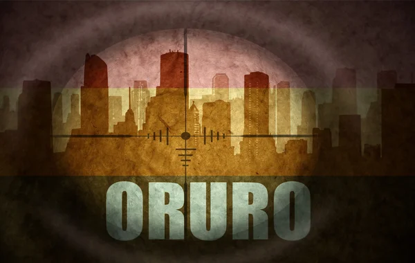 Sniper scope aimed at the abstract silhouette of the city with text Oruro at the vintage bolivian flag. concept — Stock Photo, Image