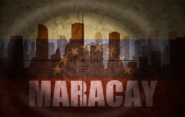 Sniper scope aimed at the abstract silhouette of the city with text Maracay at the vintage venezuelan flag. concept — Stock Photo, Image