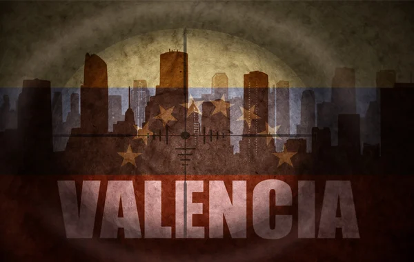 Sniper scope aimed at the abstract silhouette of the city with text Valencia at the vintage venezuelan flag. concept — Stock Photo, Image