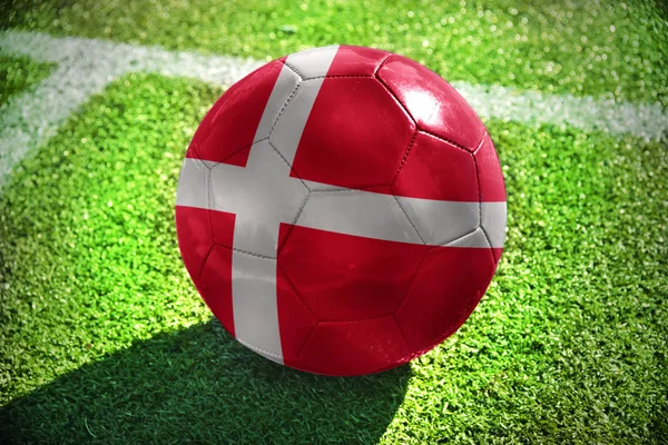 Voetbal bal met de nationale vlag van Denemarken ligt aan de groene weide in de buurt van de witte lijn — Stockfoto
