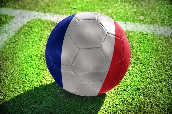 Fotboll boll med flagga Frankrike ligger på det gröna fältet nära den vita linjen — Stockfoto
