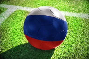 Futbol topu ile Rusya'nın ulusal bayrak beyaz satırı yakınlarında yeşil alan üzerinde yatıyor