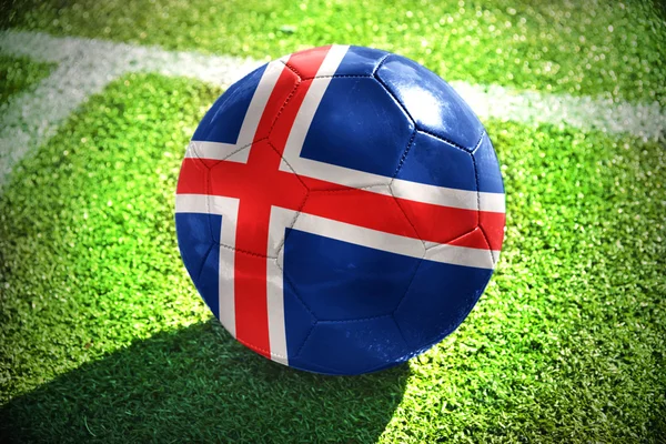Piłki nożnej z Flaga narodowa Islandii znajduje się na zielonym polu w pobliżu białej linii — Zdjęcie stockowe
