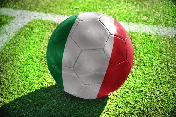 Pelota de fútbol con la bandera nacional de Italia se encuentra en el campo verde cerca de la línea blanca —  Fotos de Stock