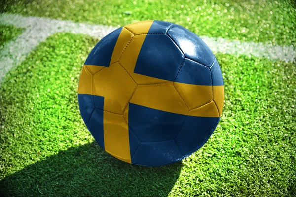 Voetbal bal met de nationale vlag van Zweden ligt op het groene veld in de buurt van de witte lijn — Stockfoto