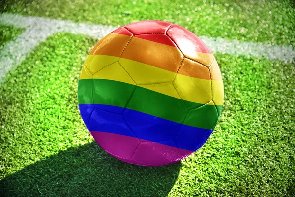 Football ball with rainbow flag on the field — Stock Photo, Image