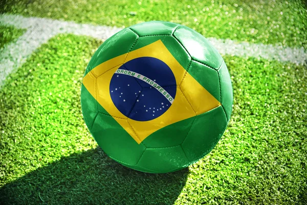 Bola de futebol com a bandeira nacional do brasil em campo — Fotografia de Stock