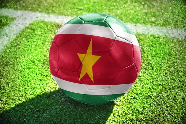 Piłka nożna piłka z flagi narodowej z Surinamu na polu — Zdjęcie stockowe