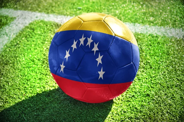 Bola de futebol com a bandeira nacional da venezuela no campo — Fotografia de Stock