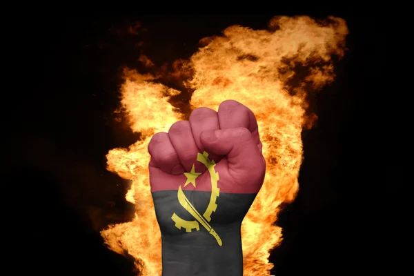Огненный фист с национальным флагом анголы — стоковое фото