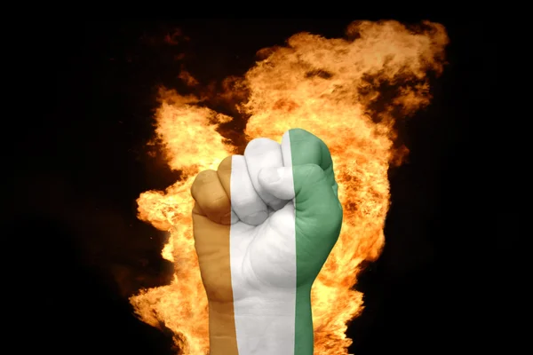Palo nyrkki kanssa lippu Norsunluurannikko — kuvapankkivalokuva