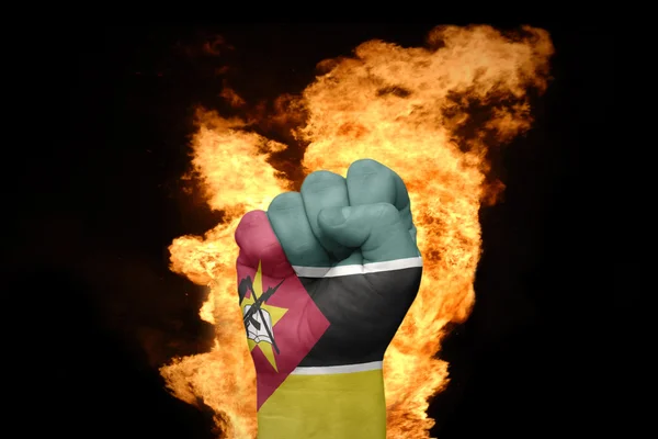 Pugno di fuoco con la bandiera nazionale del mozambico — Foto Stock