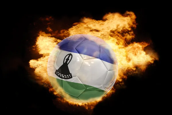 Футбольний м'яч з прапором Лесото на вогні — стокове фото