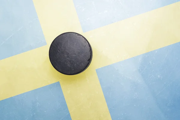 Vecchio disco da hockey è sul ghiaccio con bandiera svedese — Foto Stock