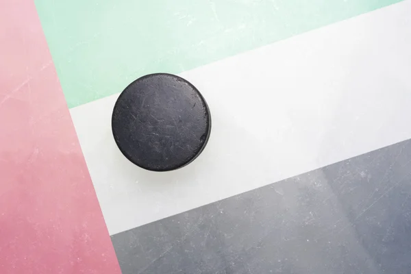 Old hockey puck is on the ice with united arab emirates flag — Stock Photo, Image