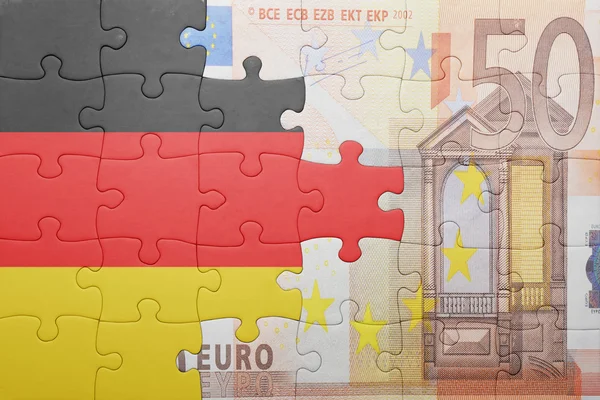Quebra-cabeças com a bandeira nacional da Alemanha e com a nota de euro — Fotografia de Stock