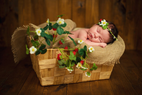 Newborn baby girl has sweet dreams in strawberries
