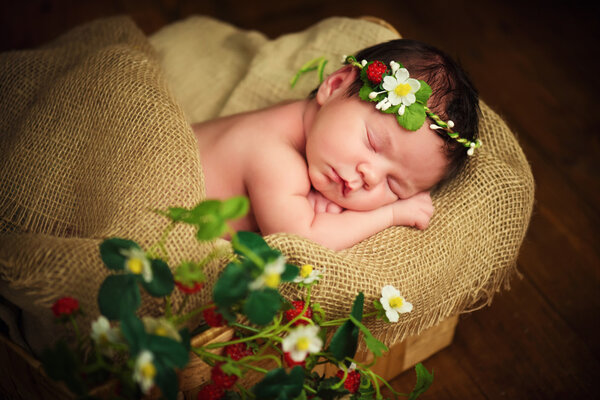 Newborn baby girl has sweet dreams in strawberries