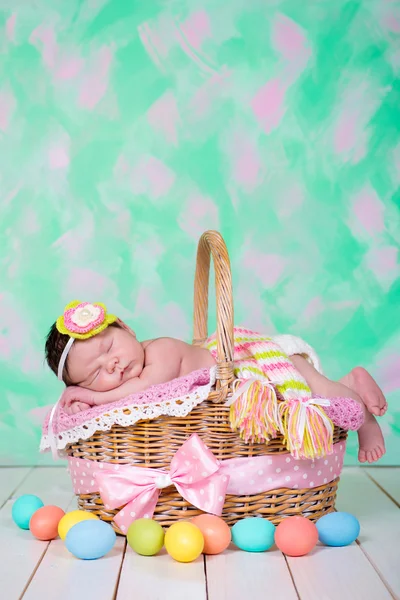 У новорожденной девочки сладкие мечты на плетеной корзине. Пасхальный праздник — стоковое фото