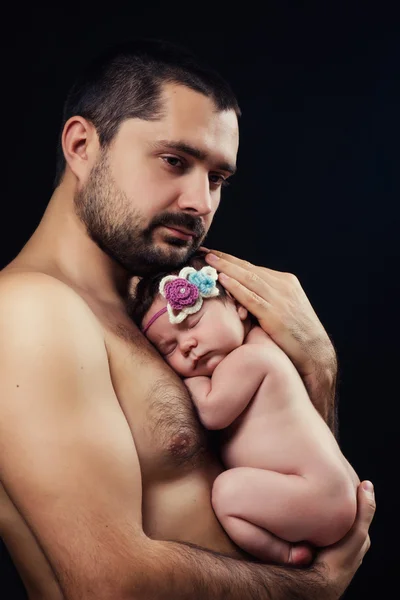Junger bärtiger Vater hält seine neugeborene Tochter sanft an der Brust — Stockfoto