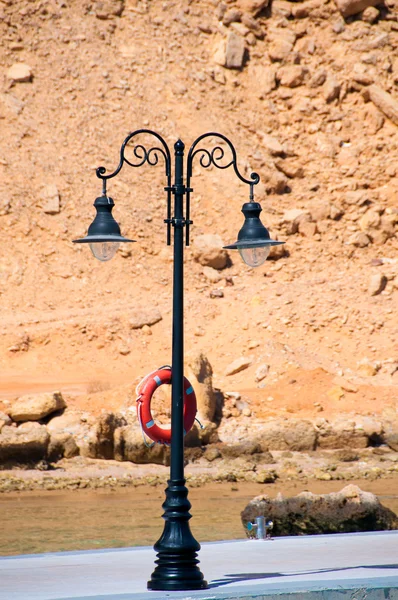 Lone wrought iron lantern on a sea berth — Stock Photo, Image