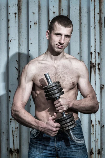 Young athletic man doing sport exercises with dumbbell — Stock Photo, Image