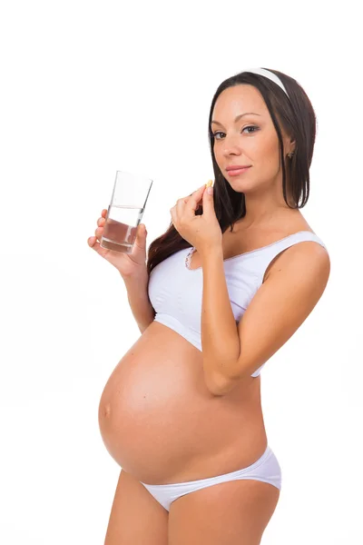 Young pregnant woman taking a pill, prenatal vitamins — Stock Photo, Image