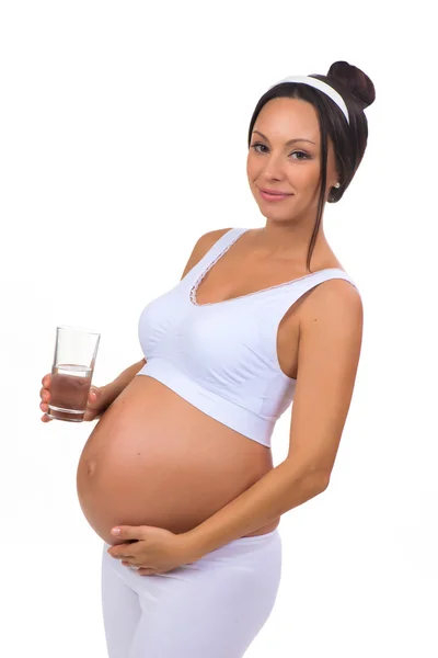 Έγκυος γυναίκα πίνοντας ένα ποτήρι νερό που απομονώνονται σε λευκό φόντο — Φωτογραφία Αρχείου