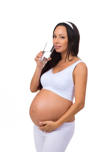Έγκυος γυναίκα πίνοντας ένα ποτήρι νερό που απομονώνονται σε λευκό φόντο — Φωτογραφία Αρχείου