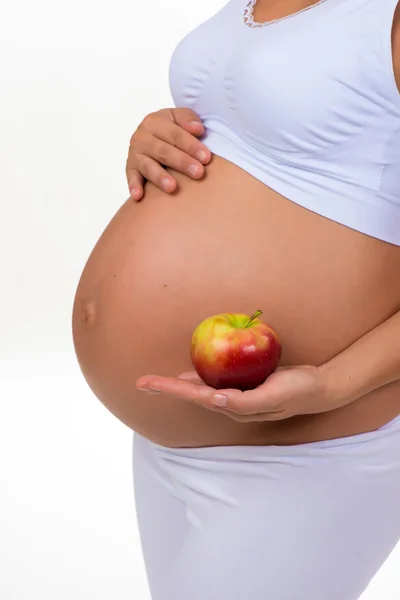 Kobieta w ciąży trzyma jabłko w jej ręce. Diety, witaminy i zdrowe jedzenie w ciąży — Zdjęcie stockowe