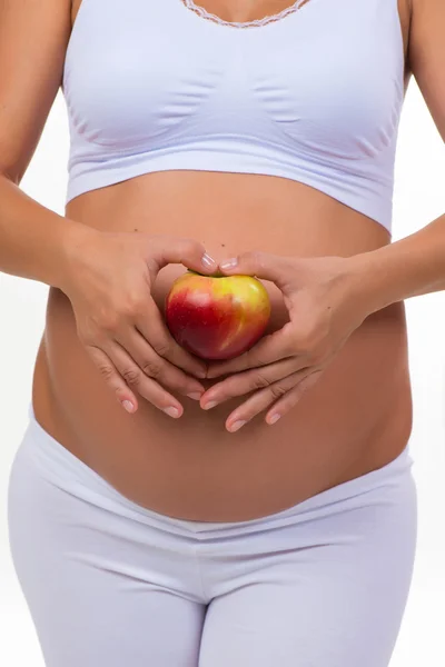 Mulher grávida segurando uma maçã. Vitaminas e alimentos saudáveis durante a gravidez — Fotografia de Stock