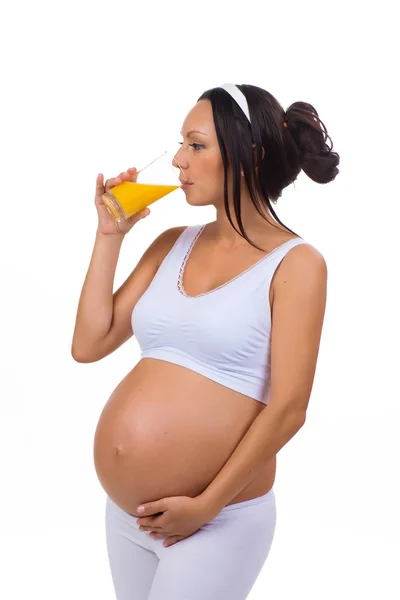 Έγκυος γυναίκα πίνοντας ένα ποτήρι φρέσκο χυμό πορτοκάλι. Απομονωμένα σε λευκό φόντο — Φωτογραφία Αρχείου