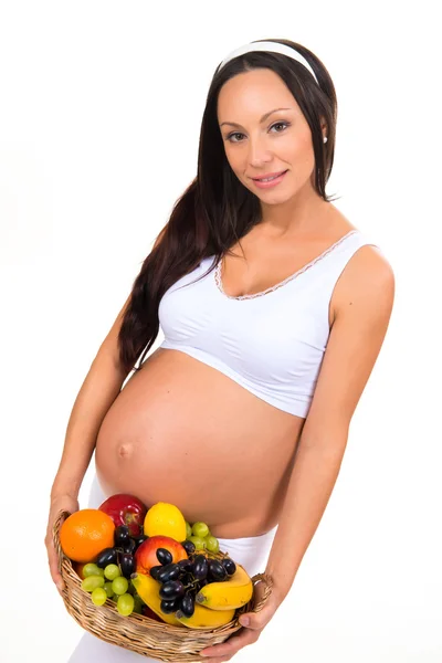 Healthy  beautiful pregnant brunette woman with a basket of fruit. Diet menu during pregnancy — Stock Photo, Image