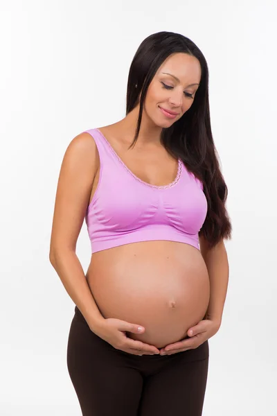 美丽的黑发怀孕女人抱着肚子。体育、 健康、 幸福的怀孕 — 图库照片