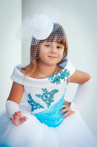 Retrato de una niña de 6 años en el exuberante vestido elegante cerca de columnas blancas — Foto de Stock