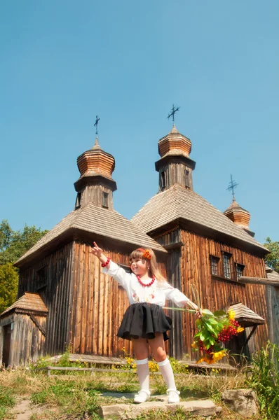 Wooden old church. Little Ukrainian girl. National Museum of Folk Architecture and Life Pirogovo — Stock Photo, Image