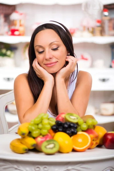 Schöne brünette Mädchen sitzt mit einem Teller mit frischem Obst. Ernährung, gesunde Ernährung und Vitamine — Stockfoto