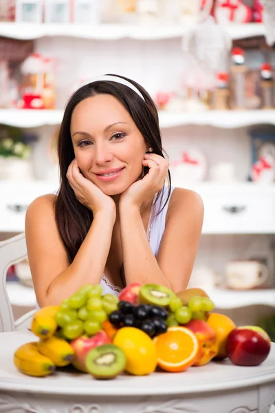 Schöne brünette Mädchen sitzt mit einem Teller mit frischem Obst. Ernährung, gesunde Ernährung und Vitamine — Stockfoto