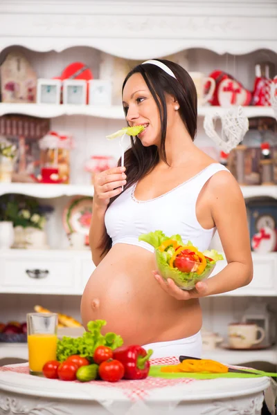 Mooie zwangere jongedame met een bord met verse groente salade. Gezonde zwangerschap, voeding, vitamine. — Stockfoto