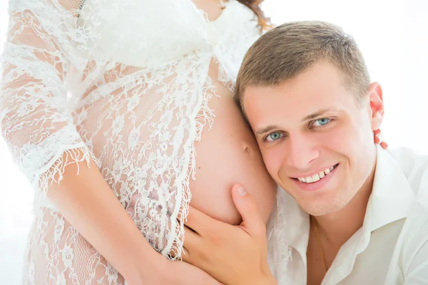 Retrato de cerca del futuro padre, abrazando y escuchando vientre embarazada — Foto de Stock