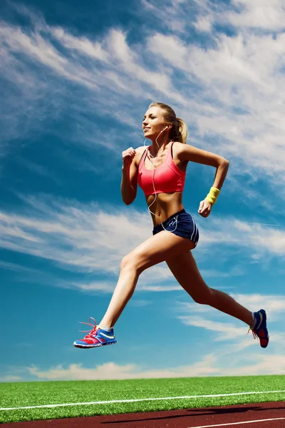 Sport running girl sullo sfondo dello stadio e del cielo — Foto Stock