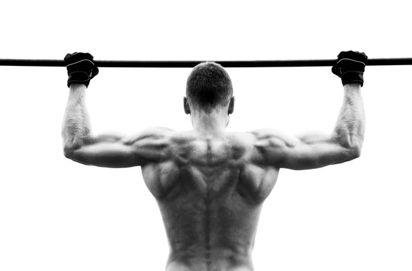 Muscle man making pull-up on horizontal bar against the sky — Stock Photo, Image