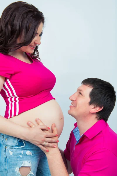 Felice famiglia incinta. Futuro papà abbraccia pancia e teneramente guarda sua moglie — Foto Stock