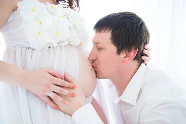 Marido abraçando e beijando barriga grávida de sua esposa, close-up retrato — Fotografia de Stock