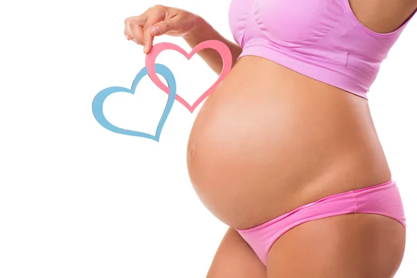 Pembe ve mavi kalpler ile hamile karnına close-up. Bebek-çocuk seks tahmin: kız, erkek ya da ikizler. — Stok fotoğraf