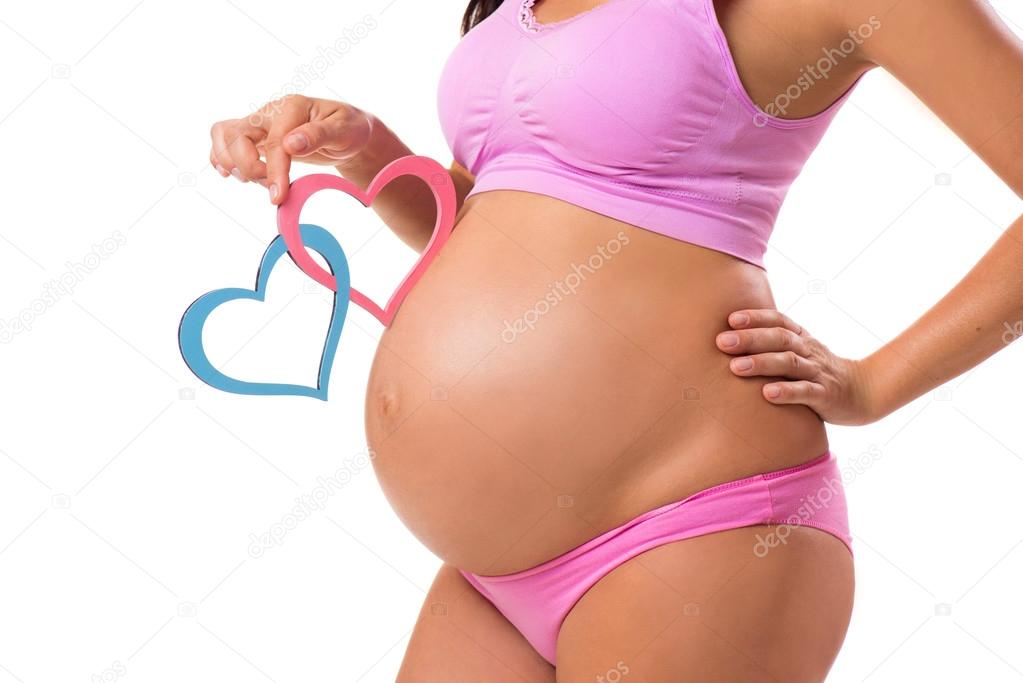 Close-up of a pregnant belly with pink and blue hearts. Guess the sex of the baby-child: girl, boy or twins.