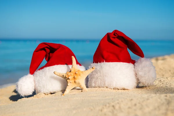 Romantic New Year at Sea. Christmas vacation. Santa hats on sandy beach